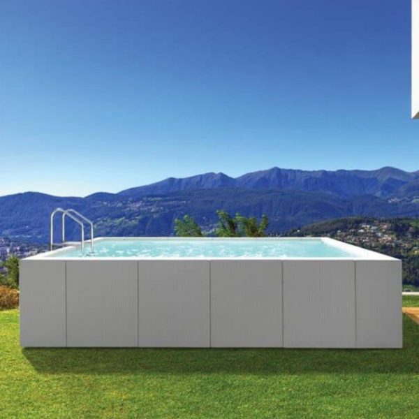 La piscina è di tipo fuori terra, con una struttura rettangolare e rivestita esternamente con pannelli dal design moderno, in fibra sintetica intrecciata a mano di colore bianca. L'acqua all'interno è cristallina e riflette la luce del sole, creando un effetto rinfrescante.